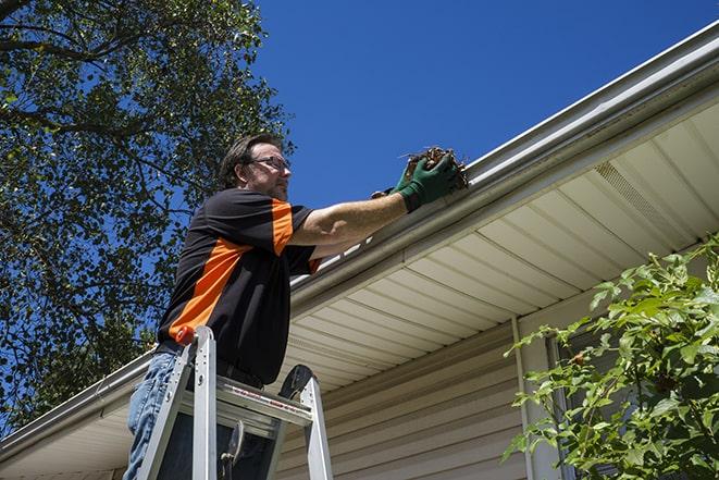 a gutter repair specialist working on a broken downspout in Victoria, MN